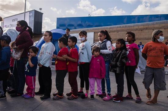 2021年3月22日，墨西哥提华纳，收容所的儿童们排长队等待领取食物救济。